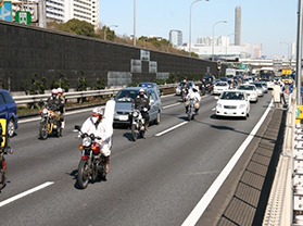 車とバイクが多数走行している画像