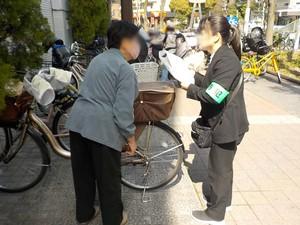 私服警察官が大規模集客施設前で自転車利用者に呼び掛けているいる写真