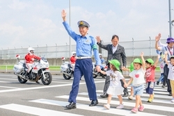 横断歩道を渡る東京空港署長と保育園児